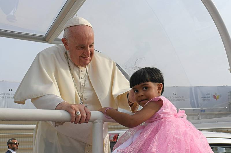 This handout photo released by the Vatican Media shows Pope Francis blessing a child as he arrives to celebrate mass at Bahrain National Stadium in Riffa, near the capital Manama. AFP