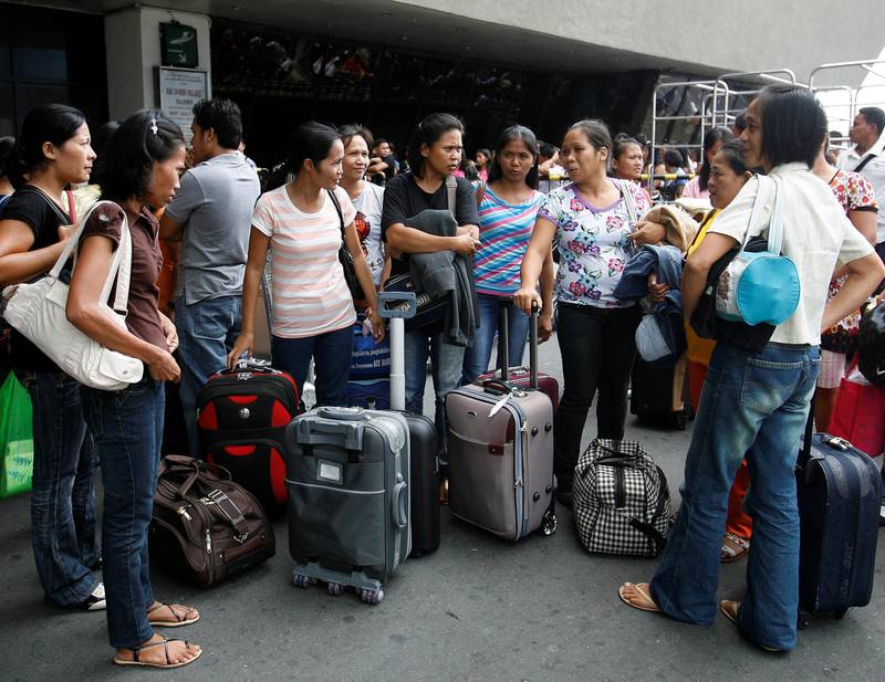A group of Filipino workers bound for the Middle East gather as they wait to board a plane at the airport in Manila in this October 9, 2010 file photo. An average of more than 3,000 workers leave the country daily to work as professionals, nurses, doctors, domestic helpers, seafarers and labourers overseas. The Philippines, the world's fourth biggest recipient of remittances after India, Mexico and China, received more than $1.5 billion worth of remittances monthly from Filipinos working and living overseas. REUTERS/Cheryl Ravelo/Files  (PHILIPPINES - Tags: EMPLOYMENT BUSINESS SOCIETY)