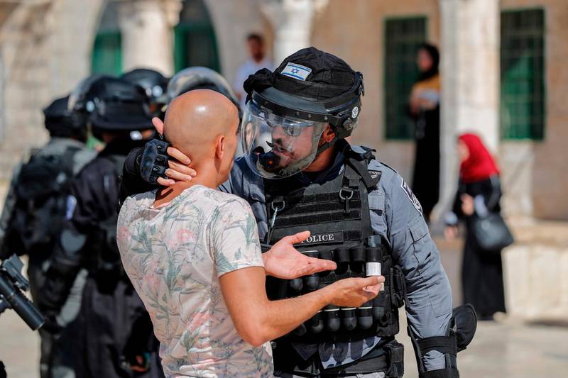 An Israeli soldier scuffles with a Palestinian at the Al Aqsa Mosque. AFP