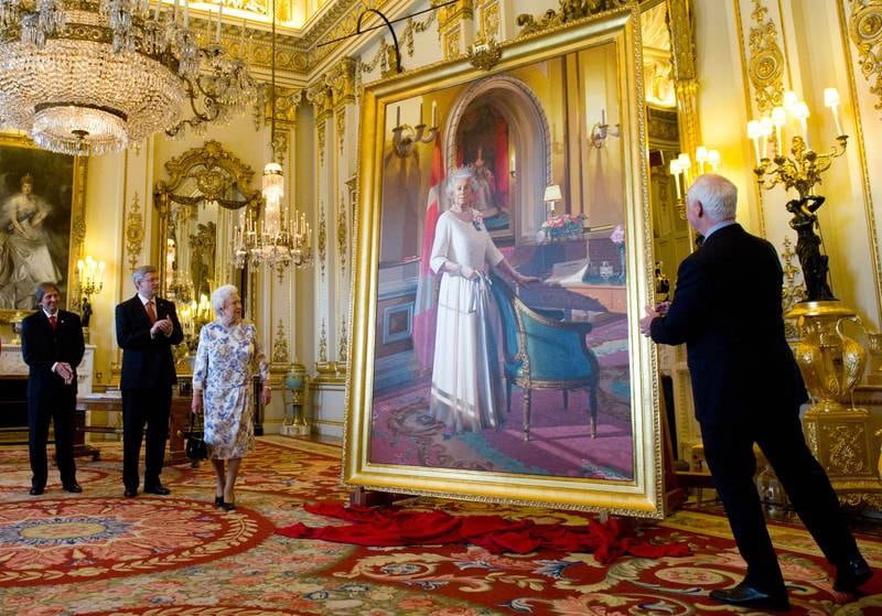 Canadian artist Phil Richards and Canada's then-prime minister, Stephen Harper, stand with Queen Elizabeth as she unveils a portrait of herself in the White Drawing Room at Buckingham Palace, in 2012. Getty Images