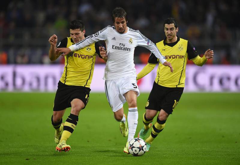 Fabio Coentrao of Real Madrid is challenged by Milos Jojic, left, and Henrikh Mkhitaryan of Borussia Dortmund during Tuesday night’s Champions League quarter-final match. Lars Baron / Bongarts / Getty Images / April 8, 2014