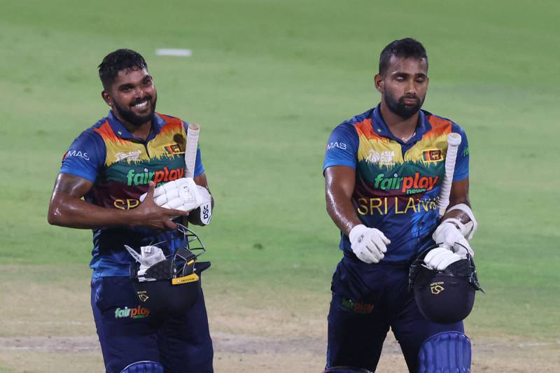Sri Lanka's Chamika Karunaratne (L) and Wanindu Hasaranga leave the field after winning the Asia Cup Twenty20 international cricket match between Sri Lanka and Afghanistan at the Sharjah Cricket Stadium in Sharjah on September 3, 2022.  (Photo by KARIM SAHIB  /  AFP)
