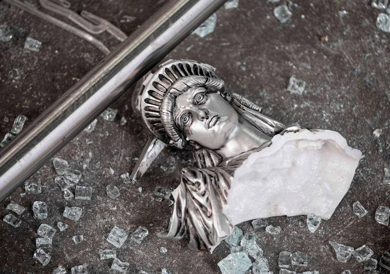 A broken Statue of Liberty figure is seen between glass shatters outside a looted souvenir shop after a night of protest against the death of  an African-American man George Floyd in Minneapolis in Manhattan in New York City.  AFP