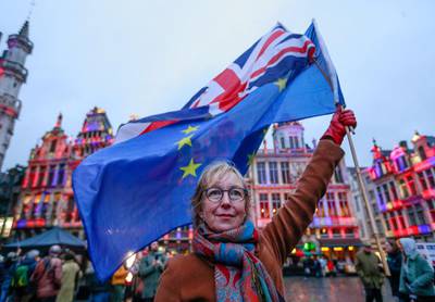 A woman holds a European flag and a Union Jack flag on the Grand Place in Brussels, Belgium.  EPA
