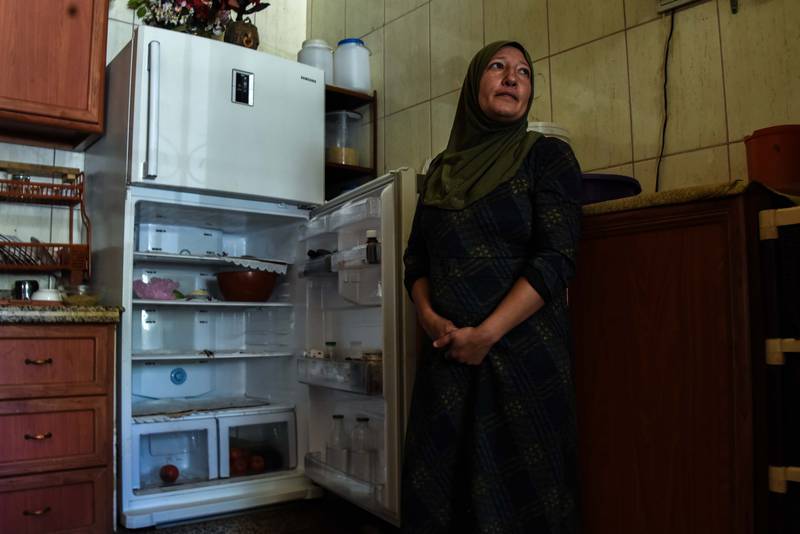 Rweida Mohammed stands next to her almost empty fridge that is warm inside due to prolonged power cuts. Elizabeth Fitt for The National
