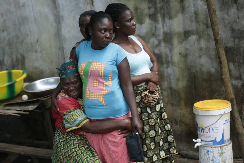 Ethel Konneh, left, is consoled by one of her daughters outside the Island Clinic Ebola isolation and treatment centre. She has just learnt her other daughter Rose Johnson passed away from Ebola in Monrovia, Liberia.  