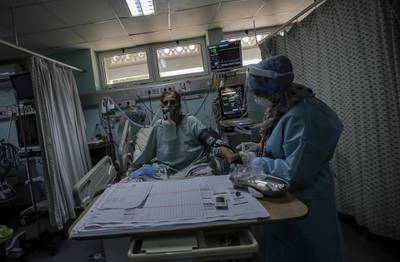 Members of the clinical staff wearing Personal Protective Equipment (PPE) care for a patient with coronavirus in the intensive care unit at the European Hospital, east of Rafah town, southern Gaza strip, 30 November 2020. The European Hospital, which has been classified as the Epidemiology Hospital since the start of the coronavirus in the Gaza Strip on 25 August 2020, has 334 infected cases under clinical care including 109 severe and critical cases. The production capacity of oxygen is 2,200 liters per minute, and there has become a large deficit after the increasing number of infections with Coronavirus.  EPA/MOHAMMED SABER