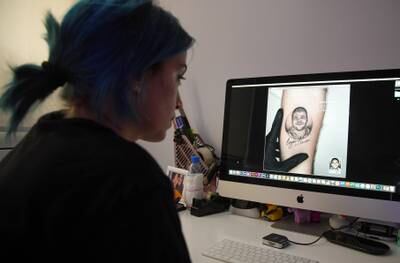 Joa Antoun, a tattoo artist, works on a drawing of Joe Noun, a firefighter, who was killed during last year's Beirut port blast.