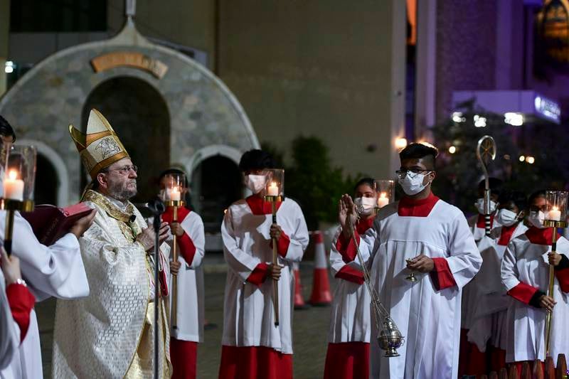 Bishop Paolo Martinelli and clergy members pray before midnight mass at St Joseph's Cathedral, Abu Dhabi. Khushnum Bhandari / The National
