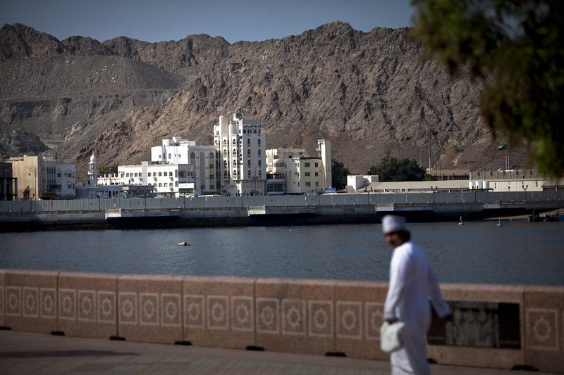 A man walks on the corniche near Mina as Sultan Qaboos Muscat in the Mutrah district in Muscat, the capital of the Sultanate of Oman on Wednesday, Oct. 12, 2011. (Silvia Razgova/The National)
