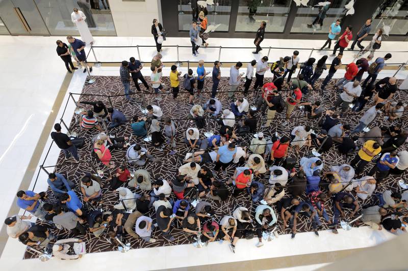 Customers queue outside the Apple store at Dubai Mall. Mahmoud Khaled / EPA