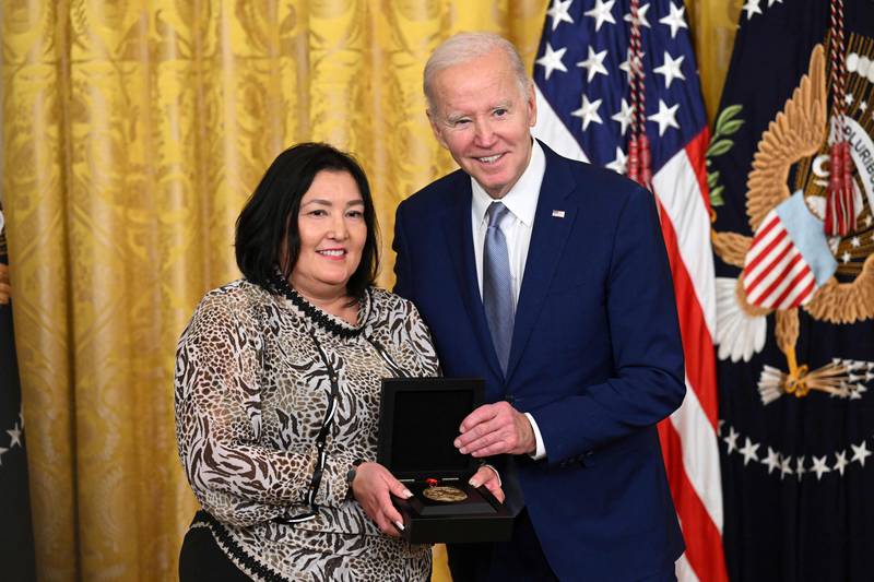 Mr Biden awards Jaclyn Sallee on behalf of Native America Calling. AFP