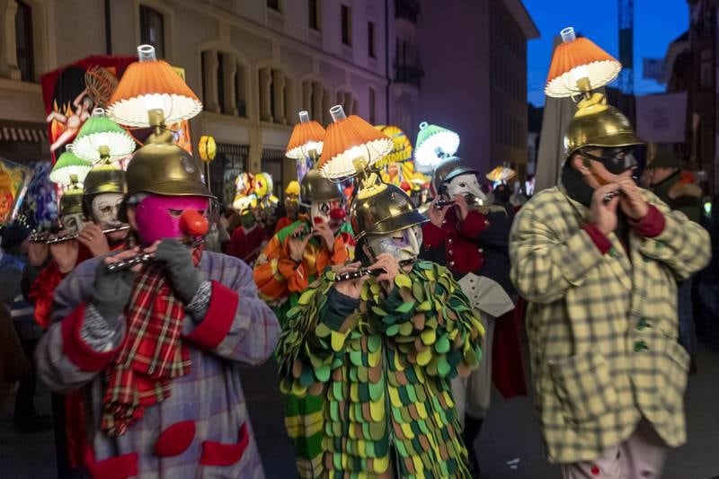 Members of carnival marching bands in costumes parade through the streets during the 'Morgestraich' carnival parade in Basel, Switzerland. EPA