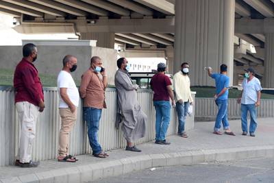 Workers wait under a bridge for odd jobs in Makkah.  AFP