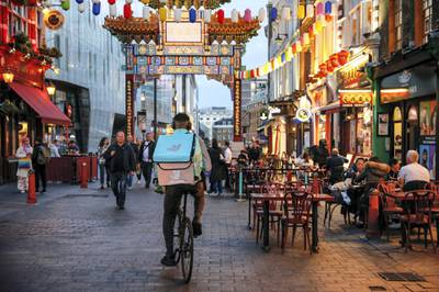 A takeaway food courier, working for Deliveroo, operated by Roofoods Ltd., stops in the Chinatown district of London, U.K., on Tuesday, Sept. 29, 2020. Covid-19 lockdown enabled online and app-based grocery delivery service providers to make inroads with customers they had previously struggled to recruit, according the Consumer Radar report by BloombergNEF. Photographer: Hollie Adams/Bloomberg via Getty Images