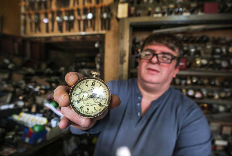 Watch repairman Youssef Abdelkarim presents an antique Omega pocket-watch as he sits at his workshop on Rasheed Street in Iraq's capital Baghdad.  AFP