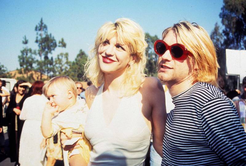 Kurt Cobain of Nirvana (right) with wife Courtney Love and daughter Frances Bean Cobain (Photo by Terry McGinnis/WireImage/Getty Images)