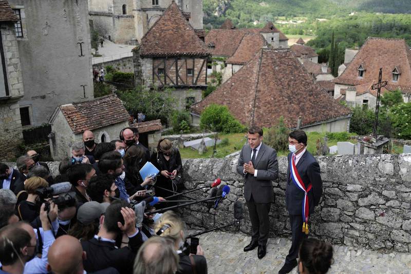 French President Emmanuel Macron (L) and mayor Gerard Miquel give a press conference  during a visit in Saint-Cirq-Lapopie, near Cahors, southwestern France, on June 2, 2021. Macron is on a two-day visit in the Lot region to promote French touristical heritage and to highlight the importance of tourism, which has been hardly hit by the pandemic, ahead of the summer holidays. / AFP / POOL / Lionel BONAVENTURE

