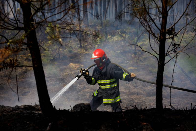 A firefighter douses flames near Louchats, south-west France. Reuters