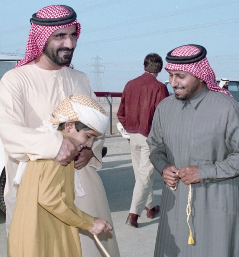 A young Sheikh Hamdan stands with his father.