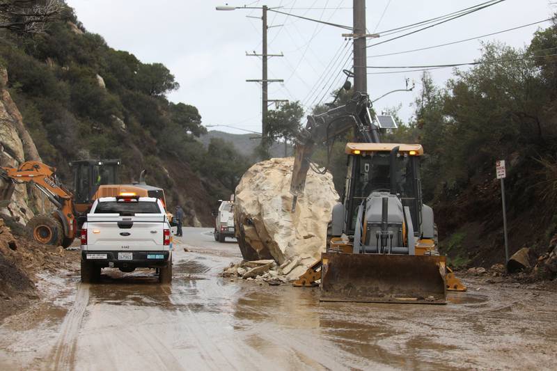 CalTrans workers chip away at a huge boulder that fell on Malibu Canyon Road in Malibu. Reuters