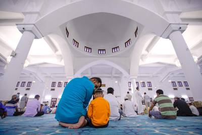 Abu Dhabi, United Arab Emirates, August 11, 2019.  Eid prayers at Zayed The 2nd Mosque. --  A father and son together for Eid prayers.Victor Besa/The NationalSection:  NAReporter: Haneen Dajani