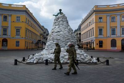 Ukrainian soldiers walk past a monument of the city founder Duke de Richelieu, covered with sand bags for protection, in Odessa, Ukraine. Reuters