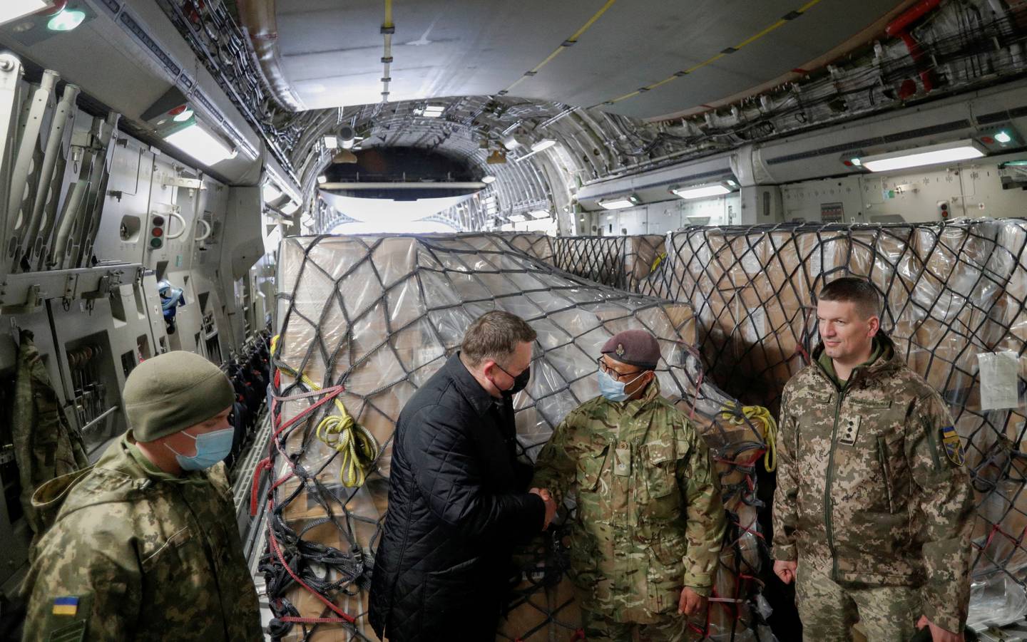 Officials, including British and Ukrainian service members, before unloading Britain's security support package for Ukraine, at Boryspil International Airport, outside Kyiv. Reuters