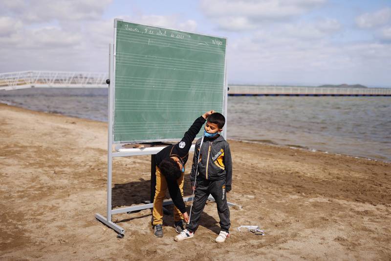 Students of the Felix Rodriguez de la Fuente school joke at the end of their class, as part of a project known as 'Aire Limpio' (Fresh Air) at the Playa de los Nietos, which aims to provide better air quality for children during the pandemic, near Cartagena, southern Spain. EPA