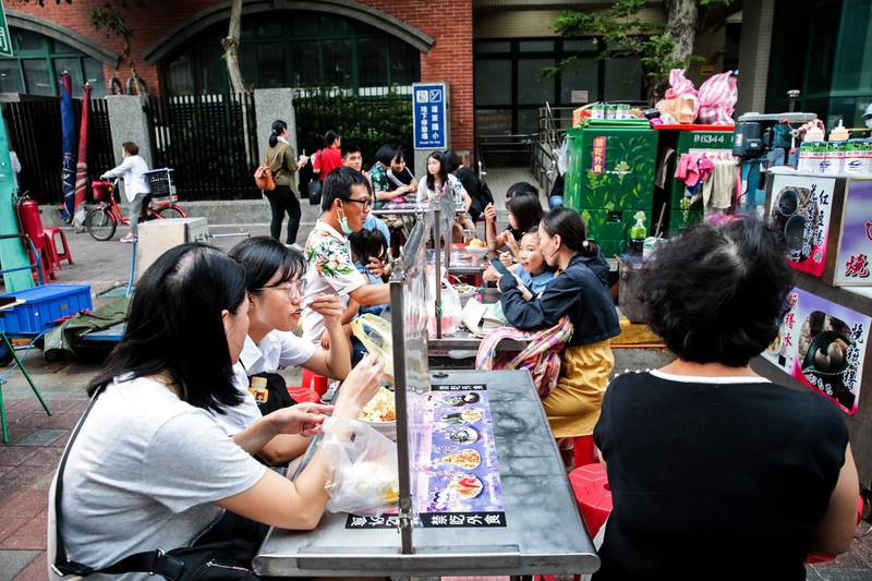 People eat their meals behind partitions at a food stall at the Ningxia Night Market in Taipei, Taiwan. Bloomberg