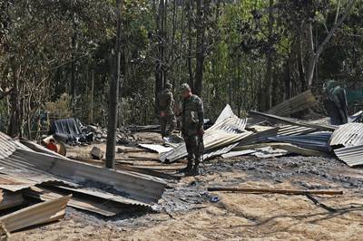 Soldiers inspect the remains of homes that were torched in Senapati, in violence from which about 23,000 people have fled. AFP