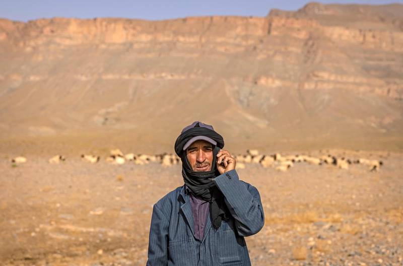 An Amazigh man poses for a picture next to a herd of sheep near the village of Amellagou. Water for livestock is hard to find and the harsh climate threatens his way of life.