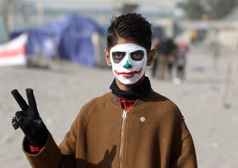 A protester wearing face-paint imitating "The Joker" poses for a picture near a sit-in by Senak bridge over the Tigris in Baghdad. AFP