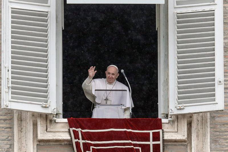 Pope Francis waves after reciting the Angelus prayer from his studio window overlooking St. Peter's Square, at the Vatican, Sunday, Feb. 7, 2021. (AP Photo/Gregorio Borgia)