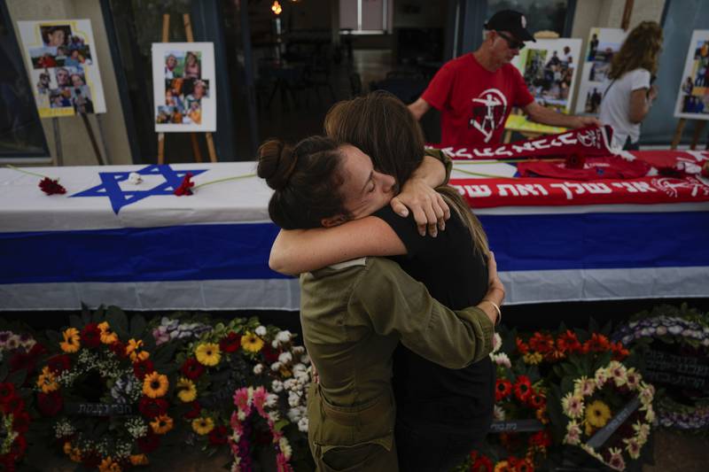 Mourners embrace during the funeral of Israeli victims of Hamas. AP