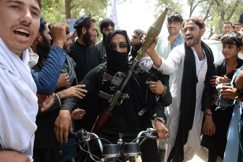 (FILES) In this file photo taken on June 16, 2018, an Afghan Taliban militant (C) carries a rocket launcher as he stands with residents as they took to the street to celebrate the ceasefire on the second day of Eid in the outskirts of Jalalabad. Extraordinary scenes of Afghan Taliban and security forces spontaneously celebrating a historic ceasefire showed many fighters on both sides were fed up with the conflict, raising hopes that peace in the war-torn country was possible, analysts said.  - TO GO WITH Afghanistan-unrest-ceasefire,FOCUS by Allison Jackson
 / AFP / NOORULLAH SHIRZADA / TO GO WITH Afghanistan-unrest-ceasefire,FOCUS by Allison Jackson
