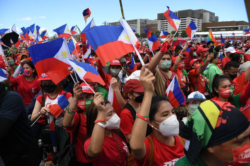 Supporters of presidential candidate Ferdinand Marcos Jr wave national flags in Paranaque City, suburban Manila. AFP