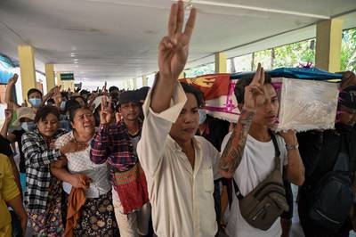 Mourners hold up the three-finger salute as they carry the coffin during the funeral of teenage protester Aung Kaung Htet in Yangon. AFP