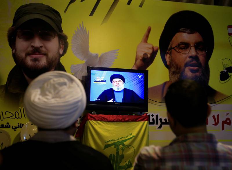 A Shi'ite sheikh watches Lebanon's Hezbollah leader Sayyed Hassan Nasrallah speaking on television in Nabatieh in southern Lebanon, August 4, 2017. REUTERS/Ali Hashisho