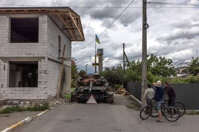 Members of the public look at a Ukrainian tank destroyed in a Russian attack, in Hostomel, north-west of Kyiv. EPA