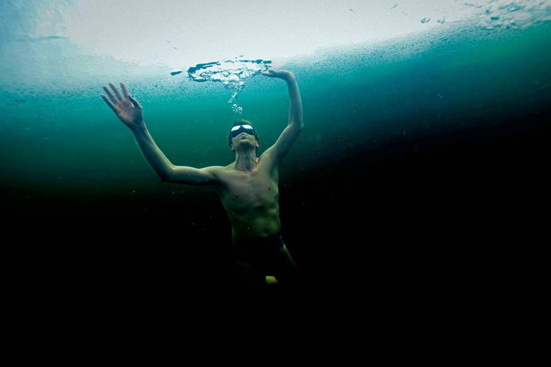TOPSHOT - Finland's freediver Kristian Maki-Jussila, 37, swims under the ice in a frozen lake on March 28, 2020.  On March 21, 2020, Kristian Maki-Jussila did the unofficial world record of swimming distance freediving in bathing suit of 101m, in a  frozen lake in Northern Finland. / AFP / Olivier MORIN

