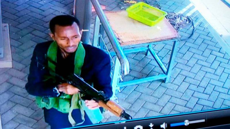 In this grab taken from security camera footage released to the local media, an armed attacker walks in the compound of a hotel, in Nairobi, Kenya, Tuesday, Jan. 15, 2019. Extremists launched an attack on a luxury hotel in Kenya's capital, sending people fleeing in panic as explosions and heavy gunfire reverberate through the neighborhood. A police officer says he saw bodies, "but there was no time to count the dead." Al-Shabab _ the Somalia-based extremist group _ is claiming responsibility. (Security Camera Footage via AP)