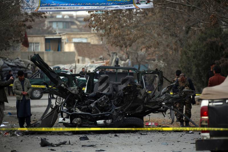 Afghan security personnel remove a damaged vehicle from the site of a bomb attack in Kabul, Afghanistan, Saturday, Feb. 20, 2021. Three separate explosions in the capital Kabul on Saturday killed and wounded multiple people, an Afghan official said. (AP Photo)