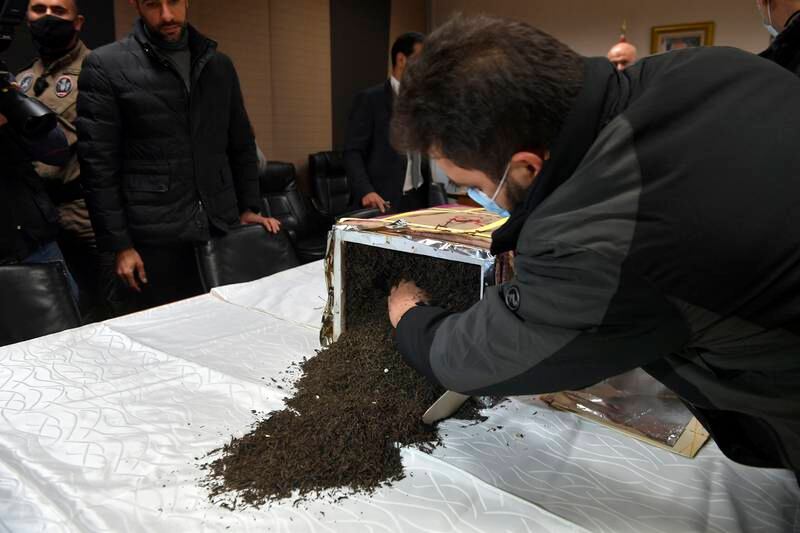A member of Lebanon's security forces shows how the drugs were hidden deep within what looked like legitimate cargo. EPA