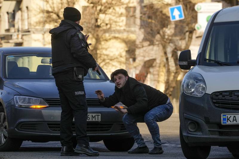 A Ukrainian police officer detains a driver on a street in Kiev. AP