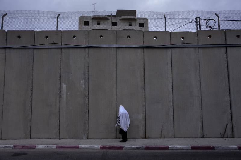 An ultra-orthodox Jewish man prays next to the separation wall built by Israel at Rachel's Tomb, Judaism's third-holiest shrine, in the occupied West Bank town of Bethlehem. AP