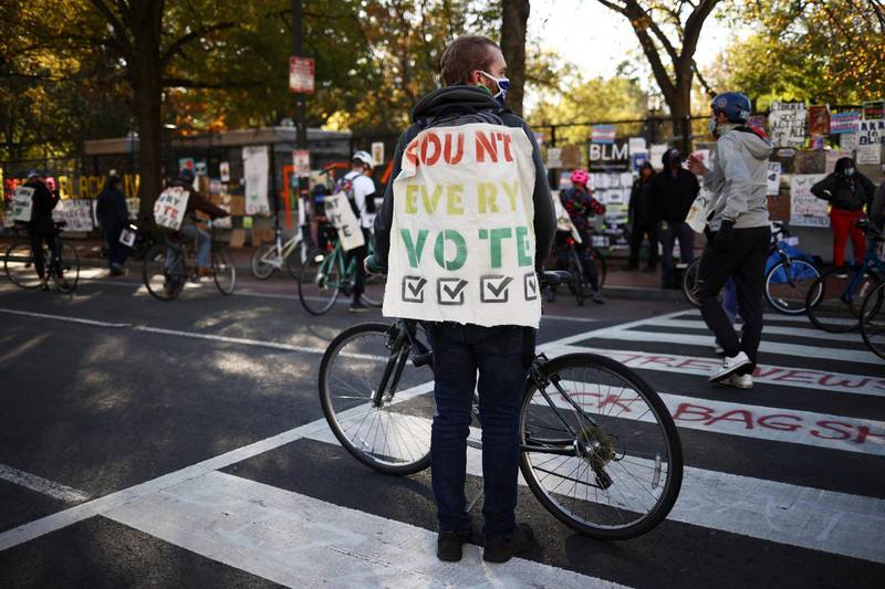 A cyclist wears a banner at Black Lives Matter plaza near the White House after Election Day in Washington, U.S., November 5, 2020. REUTERS/Hannah McKay
