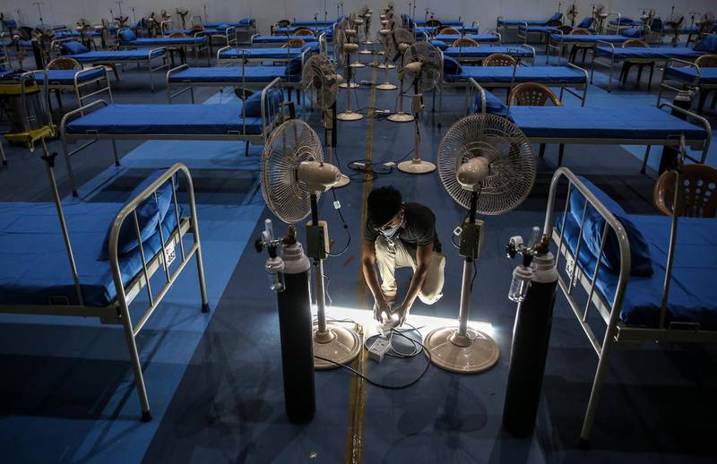 Indian workers prepare beds at the Nesco Centre Hall in Mumbai.  EPA