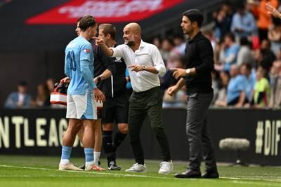 Manchester City manager Pep Guardiola gives instructions to Jack Grealish. Getty