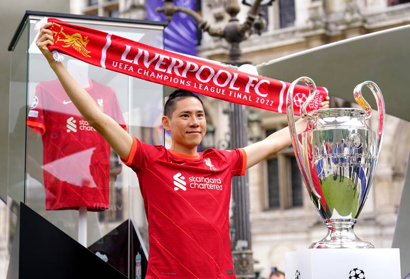 A Liverpool fan poses next to the Champions League trophy at the Place de l'Hotel de Ville in Paris ahead of Saturday's final. PA
